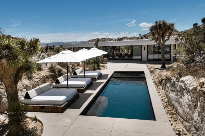 Impresionante terraza con piscina en la casa moderna de vidrio en Joshua Tree