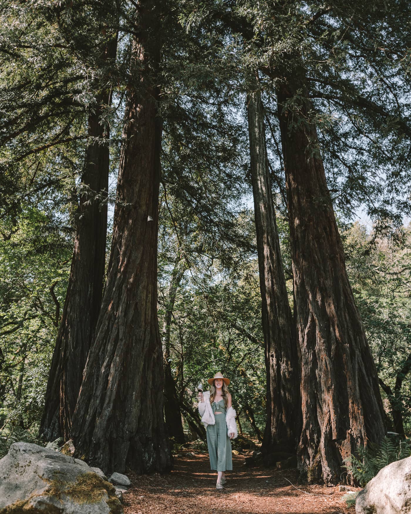 Michelle Halpern bebiendo vino bajo los árboles Redwoods en la bodega AXR
