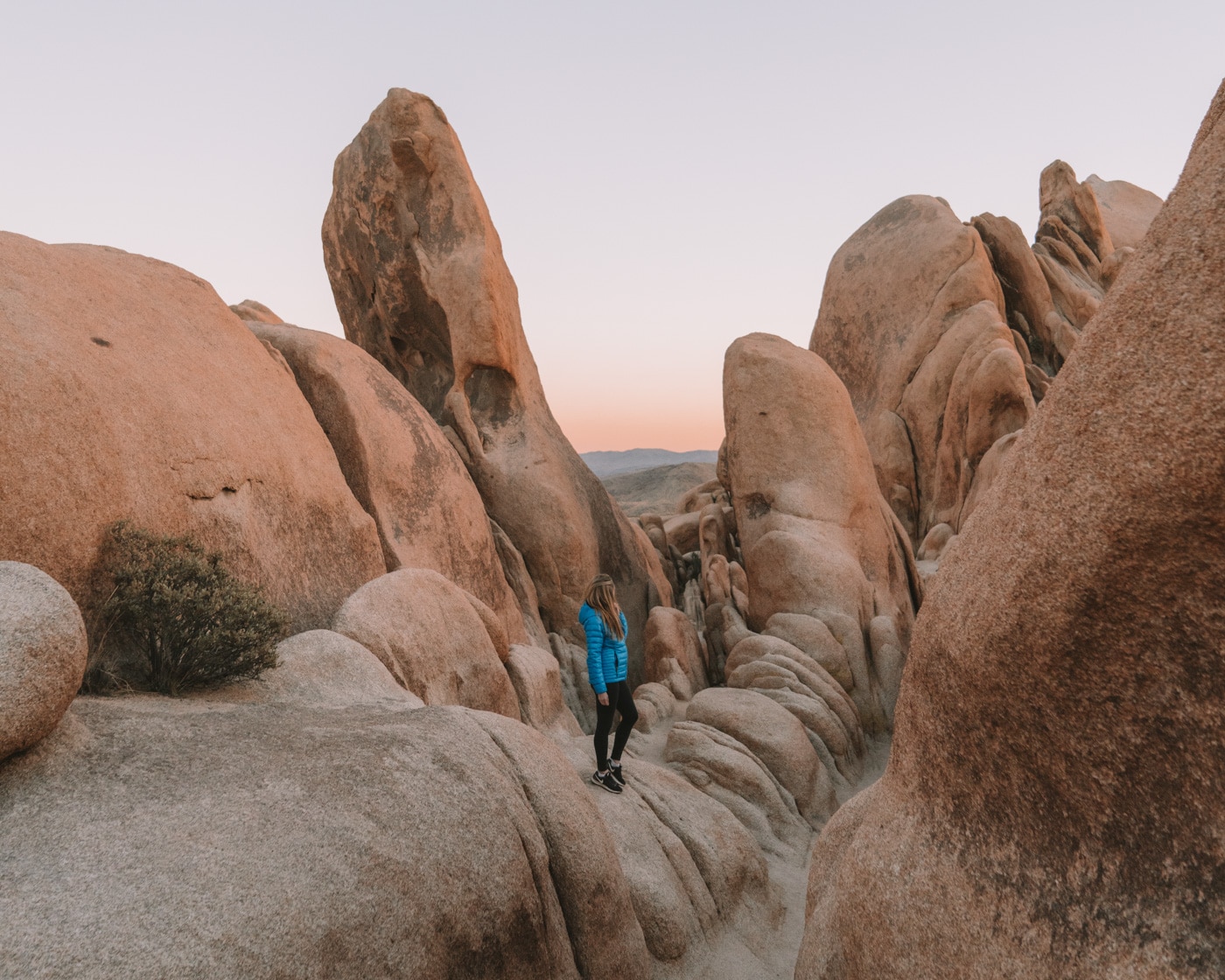 Formaciones rocosas en el Parque Nacional Joshua Tree y chica con chaqueta azul