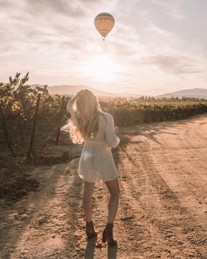 Michelle Halpern caminando en Carter Estate Winery con un globo aerostático volando por encima