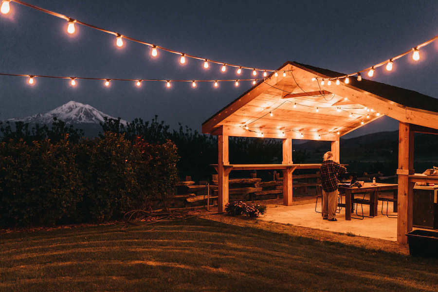 Sitio de glamping por la noche con luces de cadena